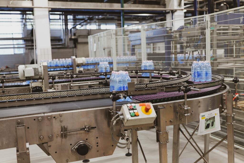 Bottiglie d'acqua su una macchina per lo stampaggio per soffiaggio durante il ciclo di produzione della lavorazione della plastica.